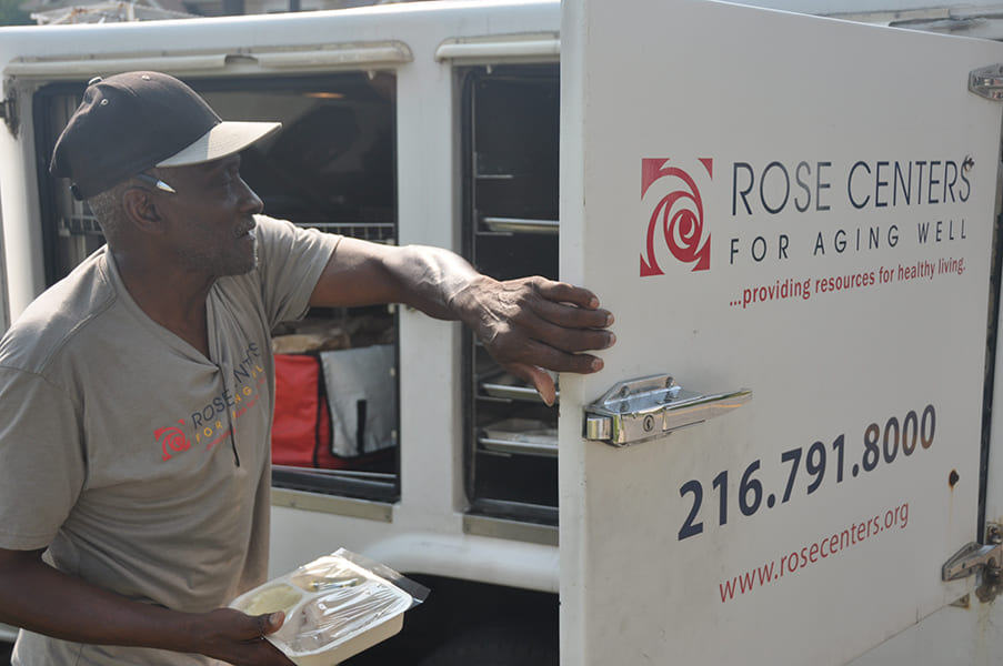 Rose Centers Home-Delivered Meals driver/jumper taking a meal out of the truck