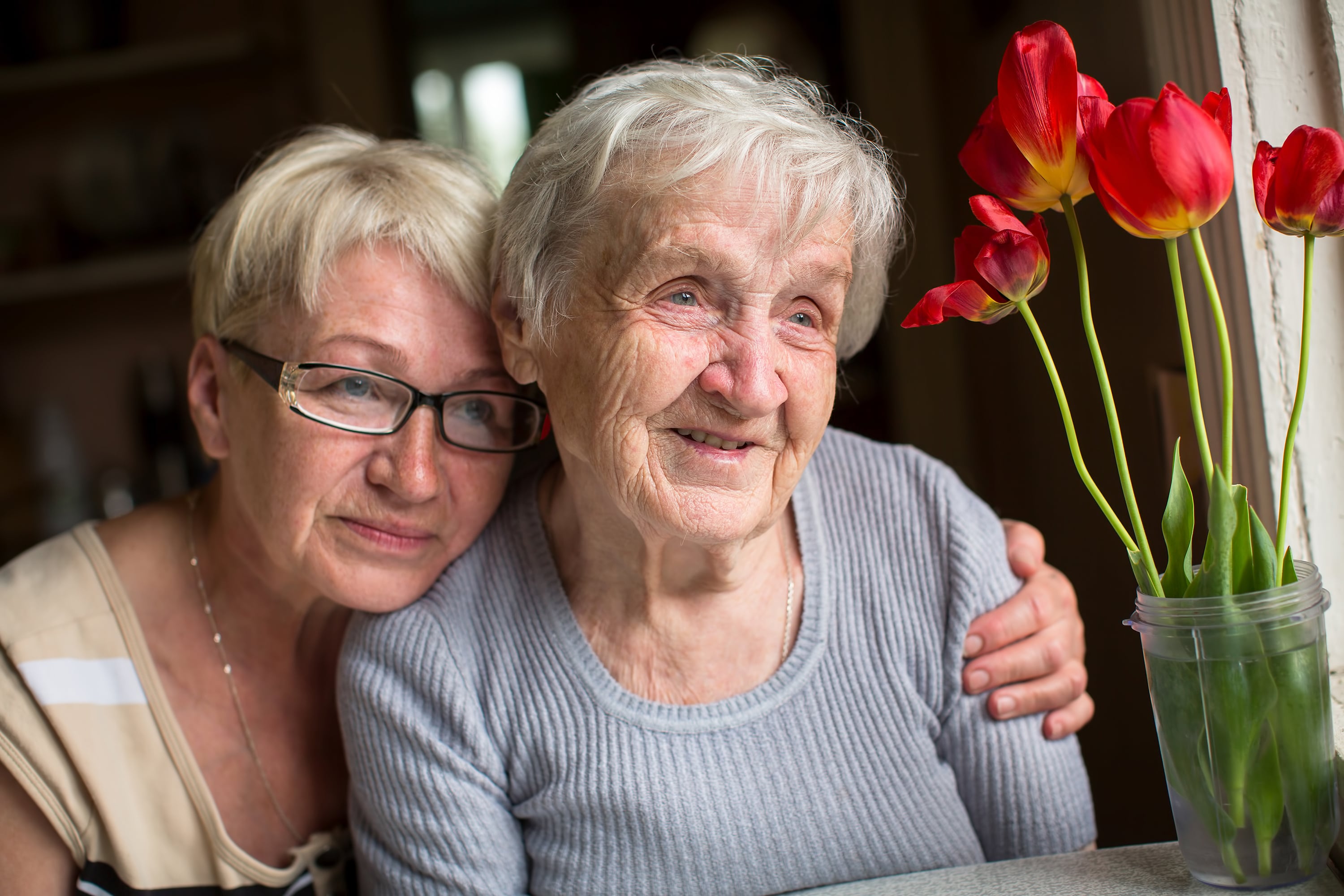 A caregiver embracing her older loved one