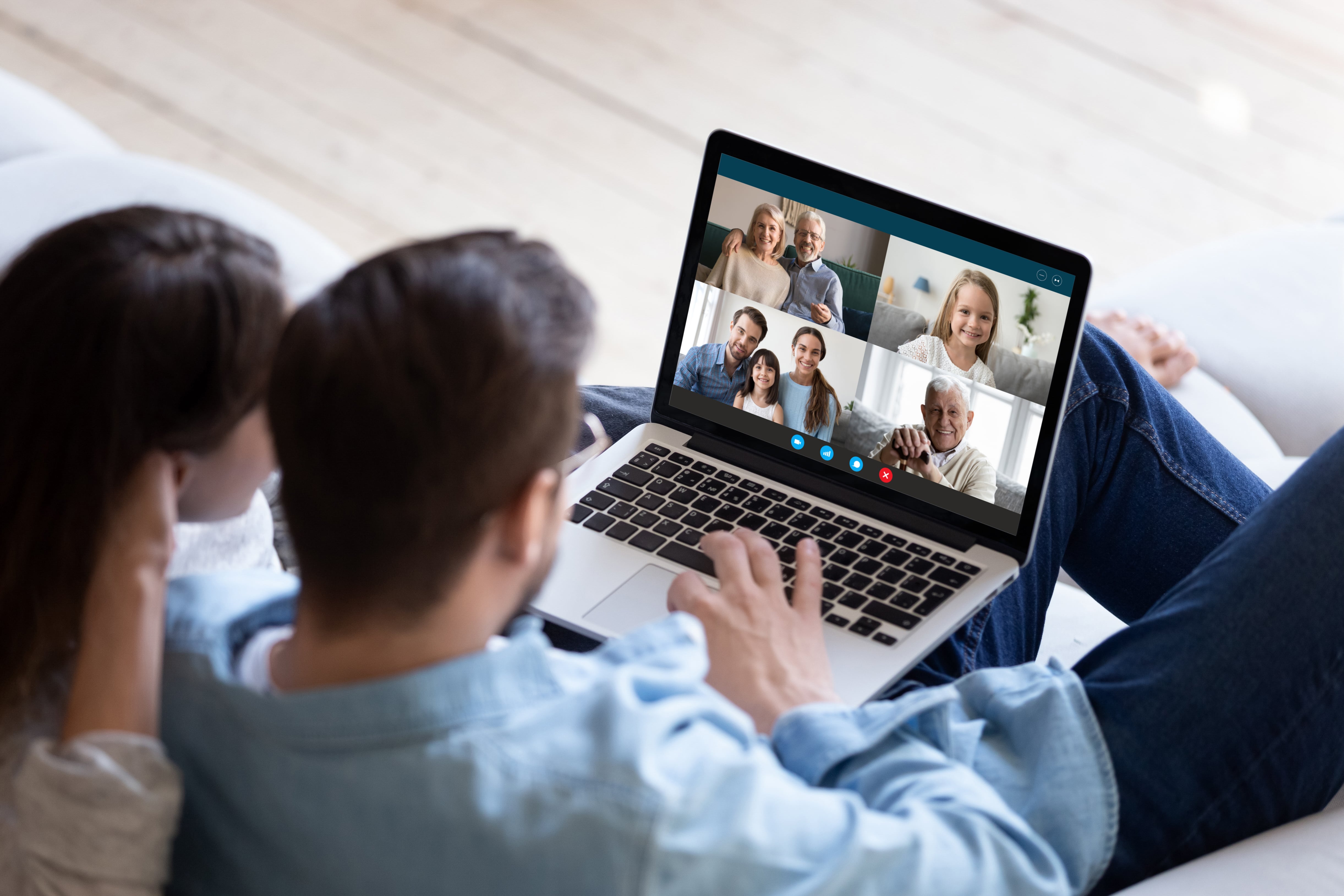 A couple having a meeting with various family members using a video conferencing platform