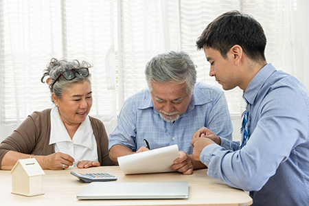 An older couple working together with a housing counselor