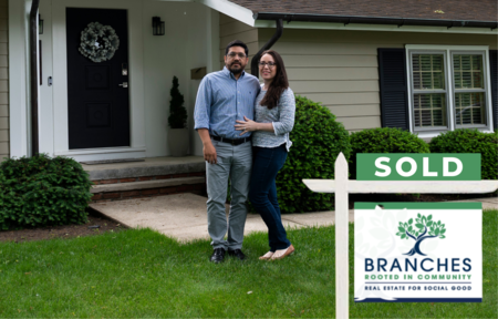 A couple standing in front of their new home, purchased through Branches Real Estate