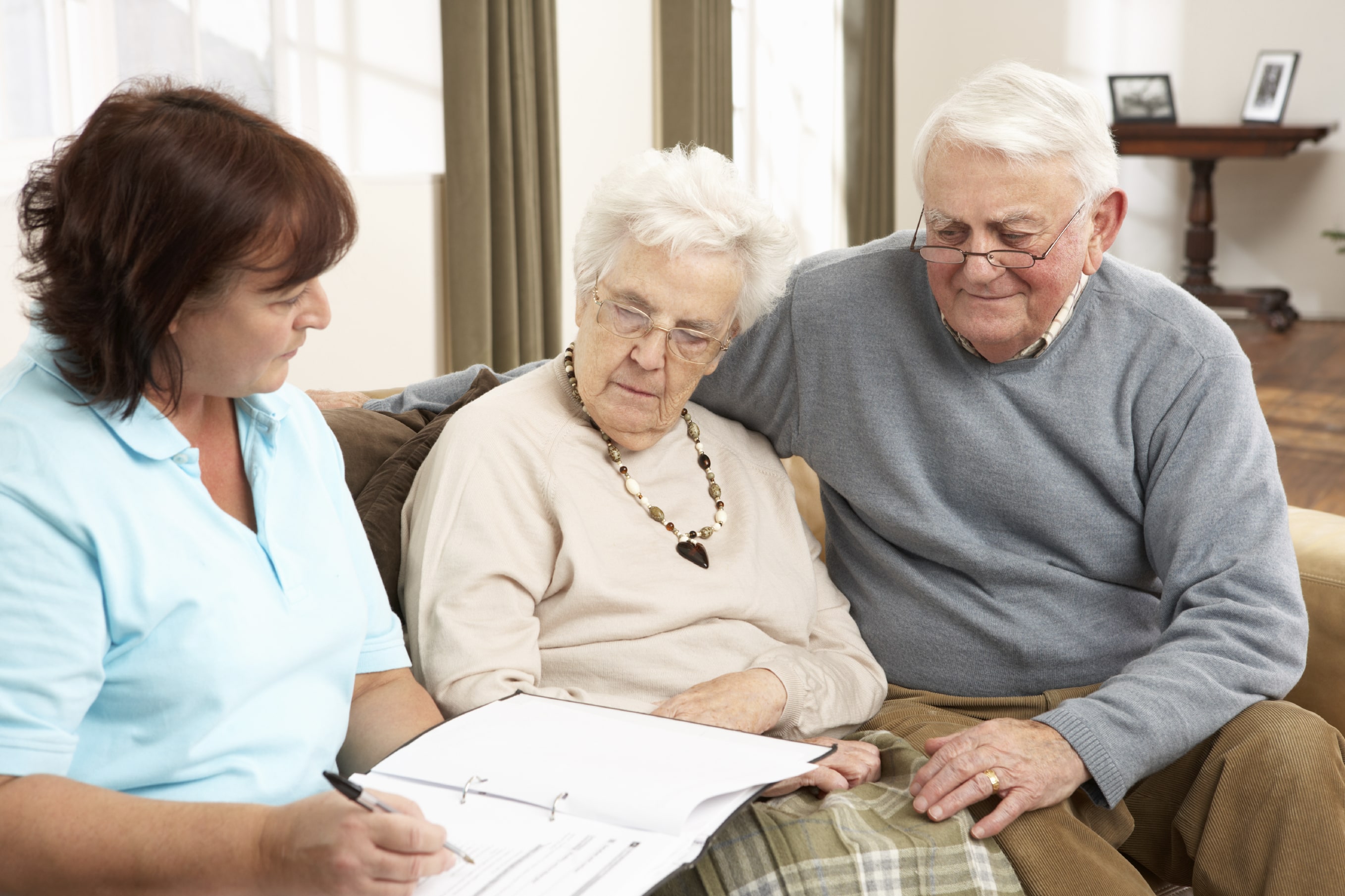 An older couple meeting with a health care professional