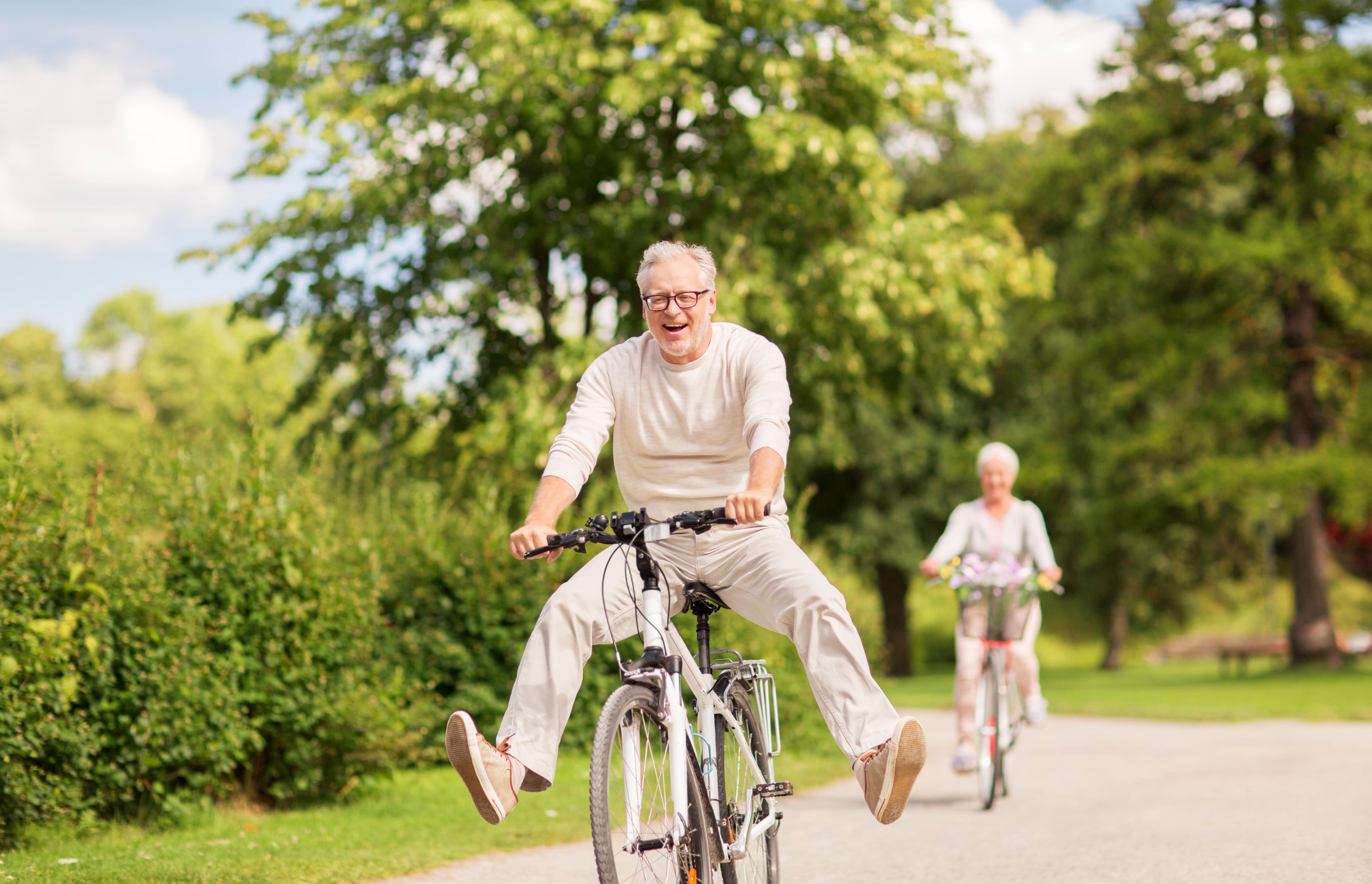 An older man joyfully riding a bike